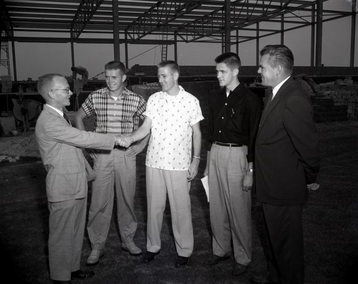 Close-up of men in front of gym construction project