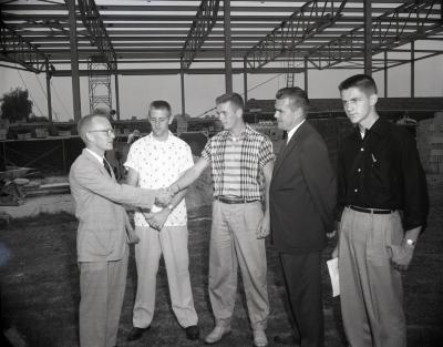 Group of men in front of gym construction